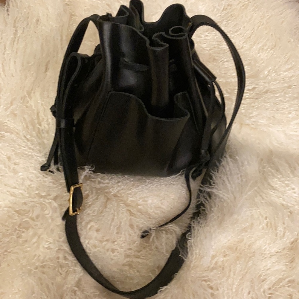 All leather Bucket bag w/ gold buckle adjustable cross body capable strap.